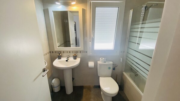 A compact bathroom with a white sink, toilet, and a glass shower enclosure. - Modern Villa 6 pax, private pool, countryside views, free wifi (Binibeca)