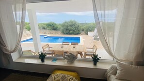 A room with a view of a pool, wooden furniture, and potted plants. - Modern Villa 6 pax, private pool, countryside views, free wifi (Binibeca)