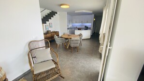A modern kitchen with white cabinets, a wooden dining table, and wicker chairs. - Modern Villa 6 pax, private pool, countryside views, free wifi (Binibeca)