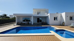 A modern two-story house with a swimming pool, outdoor seating, and a clear view of the sky. - Modern Villa 6 pax, private pool, countryside views, free wifi (Binibeca)