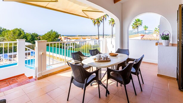 Une terrasse avec piscine, un espace repas et une vue sur la mer.