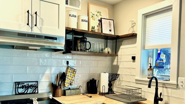 A modern kitchen with a built-in oven, a stainless steel stove, a sink, and a window with a view. - Charming 1 bed/bath Suite in waterfront Cottage (Somers)