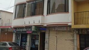 A multi-story building with a flat facade, large windows, and a visible sign for a hotel.