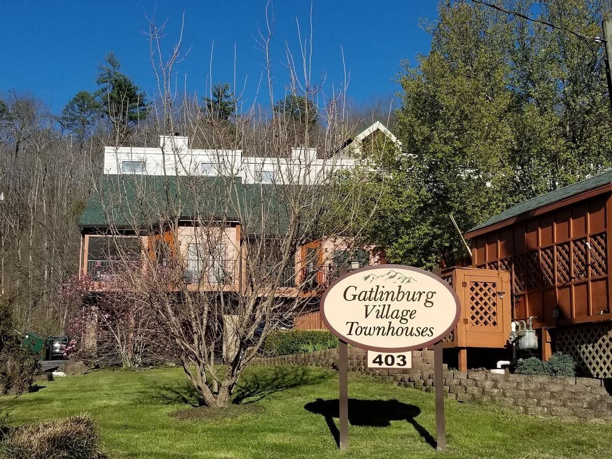 Señal para Gatlinburg Village Townhouses, número 403, con vista a los alrededores, incluyendo árboles y un edificio al fondo.