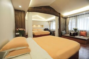 A hotel room with a large bed, a seating area with a table, and a view of the outdoors. - Xiangxingli Inn (Tengchong Heshun Ancient Town Branch) (Tengchong)