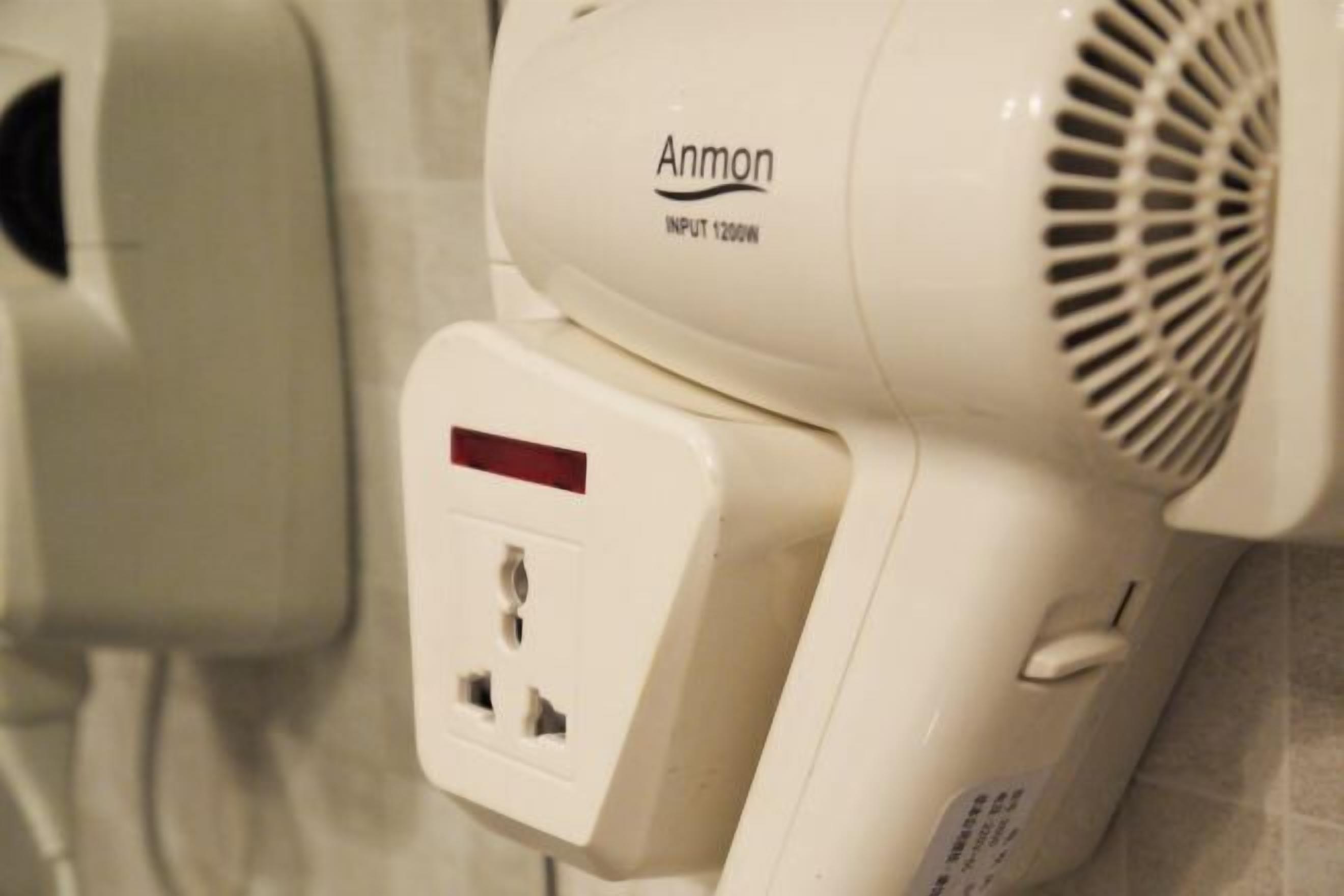 A hair dryer with a label "Anmon" and an input of 1200W.