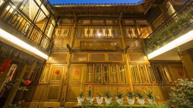 A traditional wooden building with multiple balconies and potted plants. - Xiangxingli Inn (Tengchong Heshun Ancient Town Branch) (Tengchong)