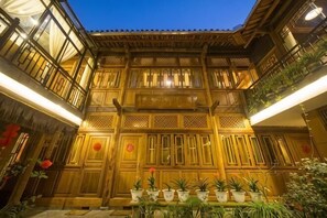 A traditional wooden building with multiple balconies and potted plants. - Xiangxingli Inn (Tengchong Heshun Ancient Town Branch) (Tengchong)