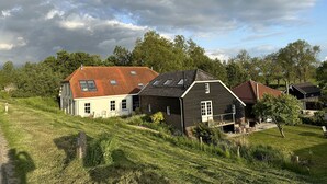 Una casa rural con techo inclinado, un granero y un césped bien cuidado.