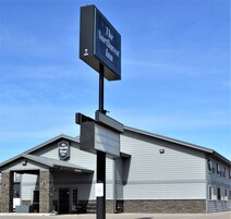 NorthWest Inn, un edificio con un letrero grande, fachada de piedra y señal que indica estacionamiento para veteranos.