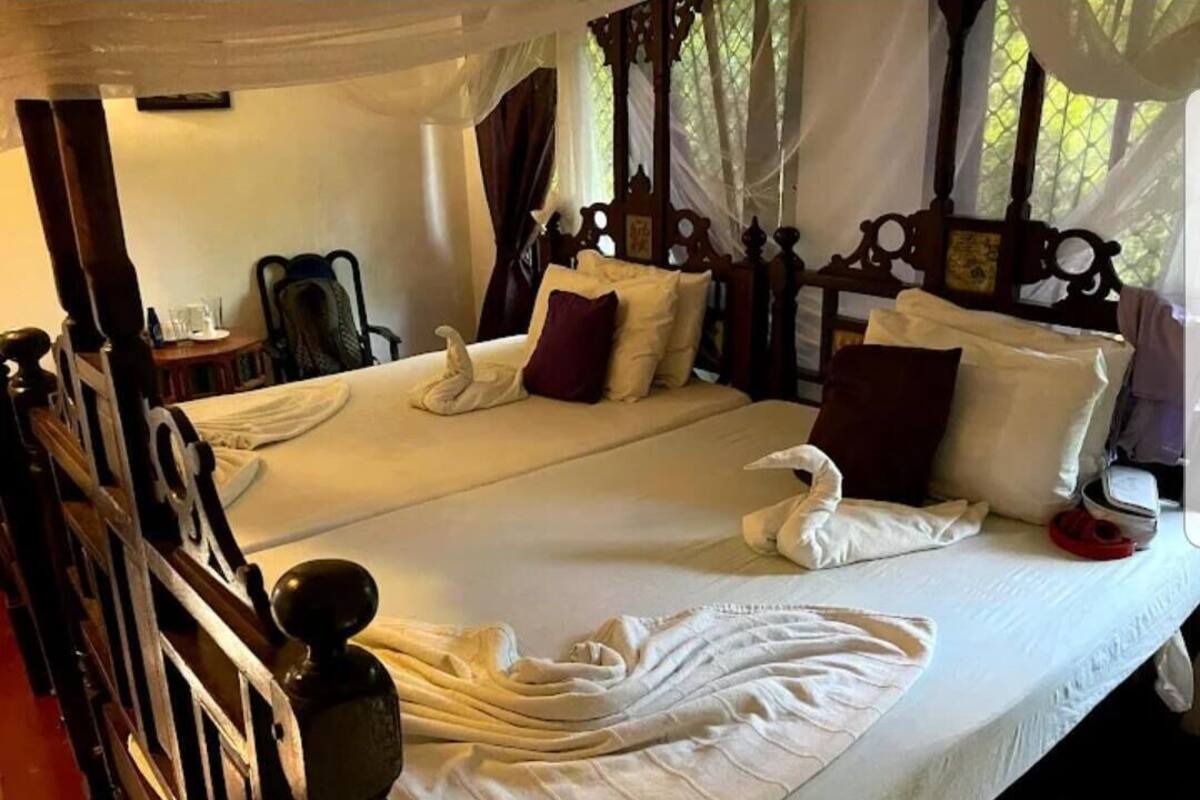 Una cama doble con dosel, almohadas y una bata sobre la cama.