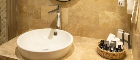 Un baño con un espejo redondo, un lavabo y un perchero para toallas.