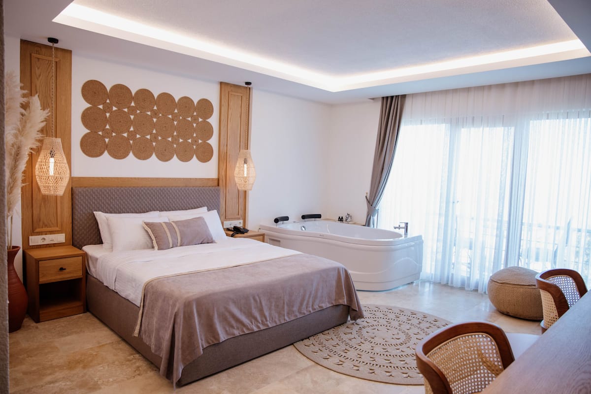 Une chambre moderne avec un grand lit, une baignoire et un coin salon.