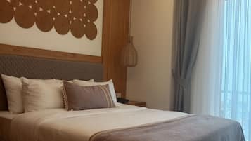 Ein modernes Schlafzimmer mit einem großen Bett, einer dekorativen Wandverkleidung, einer Pendelleuchte und Blick ins Freie durch ein Fenster mit Vorhängen.
