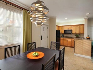 Enjoy cooking in this well-equipped kitchen with a central island, dining area, and microwave, refrigerator.