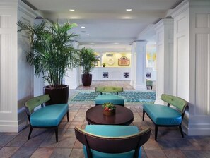 Relax in style at the reception area, featuring a cozy seating arrangement and lush greenery.