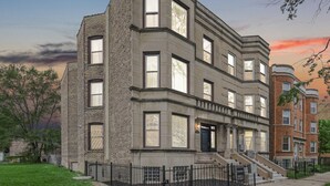 Un edificio de varios pisos con fachada de ladrillo, ventanas grandes y una entrada principal con escalones.