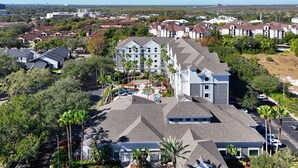 A residential area with modern houses, a gated community, and a large building with a parking lot. - Suites at Lake Buena Vista close Disney Springs with free parking (Orlando)