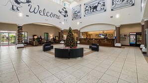 A spacious lobby with a central Christmas tree, a reception desk, and a large 'Welcome' sign featuring Mickey Mouse. - Suites at Lake Buena Vista close Disney Springs with free parking (Orlando)