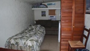 A small, compact room with a bed, a desk, and a chair. - 116 Southshore - Cute little hideaway, ready for the all around fishing (Port Mansfield)