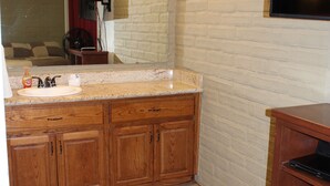 A bathroom with a wooden vanity, a sink, and a mirror.