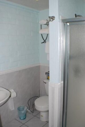A bathroom with a toilet, sink, and shower. - Fabulous Fisherman's Condo! (Port Mansfield)