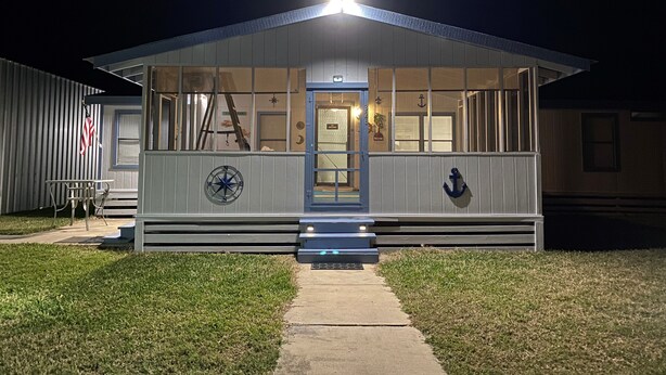 A nautical-themed building with a blue door, a compass sign, and an anchor decoration.