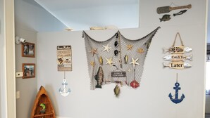 A wall decorated with nautical-themed items including fish, anchors, and a fishing net.