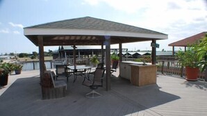 Une terrasse extérieure dotée d’un espace salon couvert, de tables et de chaises.