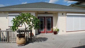 Une maison à deux étages avec un porche couvert, un garage et des plantes en pot.