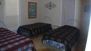 Une chambre avec deux lits simples, une carte accrochée au mur et un élément décoratif mural.