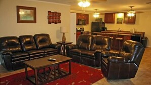 A living room with leather sofas, a coffee table, and a red patterned rug. - Knots Landing #2 - Newly remodeled 2 Bedroom/2 Bath (Port Mansfield)