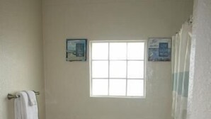A small bathroom with a toilet, a sink, and a window. - Knots Landing #2 - Newly remodeled 2 Bedroom/2 Bath (Port Mansfield)