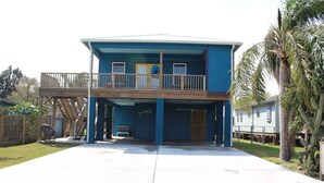 A two-story house with a balcony, a garage, and a fenced yard. - 311 Beach - Gorgeous, Brand New Home! Stunning Home with Private Pool! (Port Mansfield)