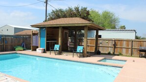 A backyard with a swimming pool, a covered patio area, and a wooden fence. - 311 Beach - Gorgeous, Brand New Home! Stunning Home with Private Pool! (Port Mansfield)