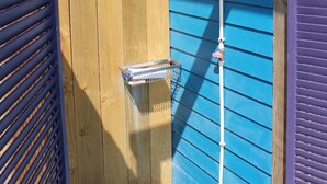 A wooden door with a metal handle, a metal shelf, and a metal pole with a light fixture. - 311 Beach - Gorgeous, Brand New Home! Stunning Home with Private Pool! (Port Mansfield)