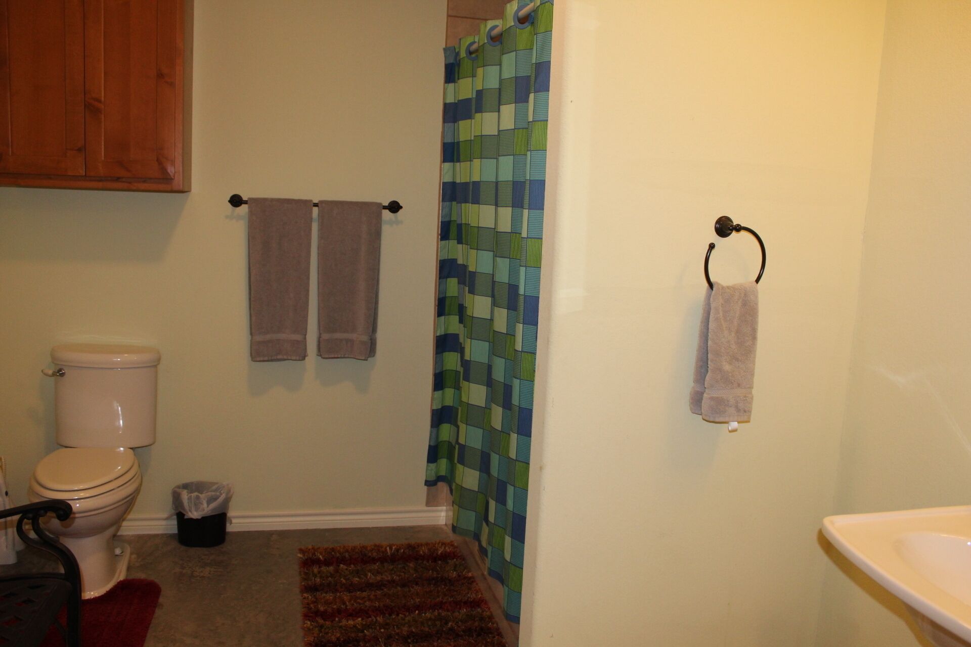 A bathroom with a toilet, a shower curtain, and a sink.