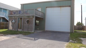 Un edificio a due piani con un balcone, un basculante per garage e un piccolo portico.
