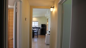 A narrow hallway leading to a kitchen with a dining area. - 201 Matagorda - Cozy, Spacious Newly Remodeled Getaway! (Port Mansfield)