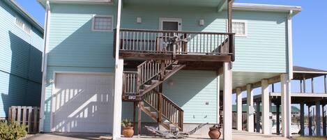 A two-story house with a covered front porch and a wooden staircase leading to the second floor.