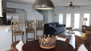 A dining area with a round table, chairs, and a decorative centerpiece. - Pelican Point #10 - Beautiful Complex, Gorgeous Sunrises & Easy Access (Port Mansfield)