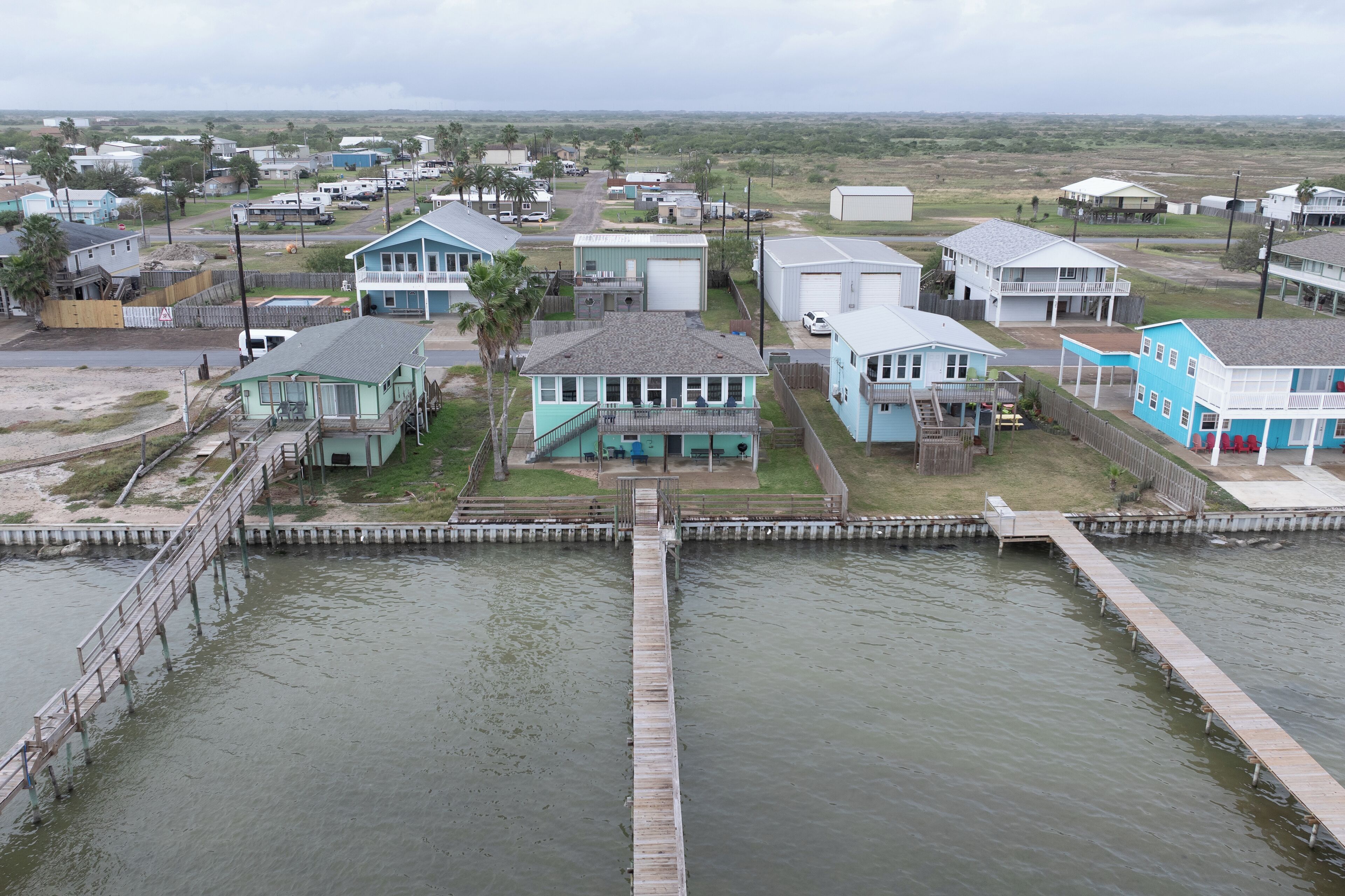 Zona residencial costera con casas, un muelle y una masa de agua.