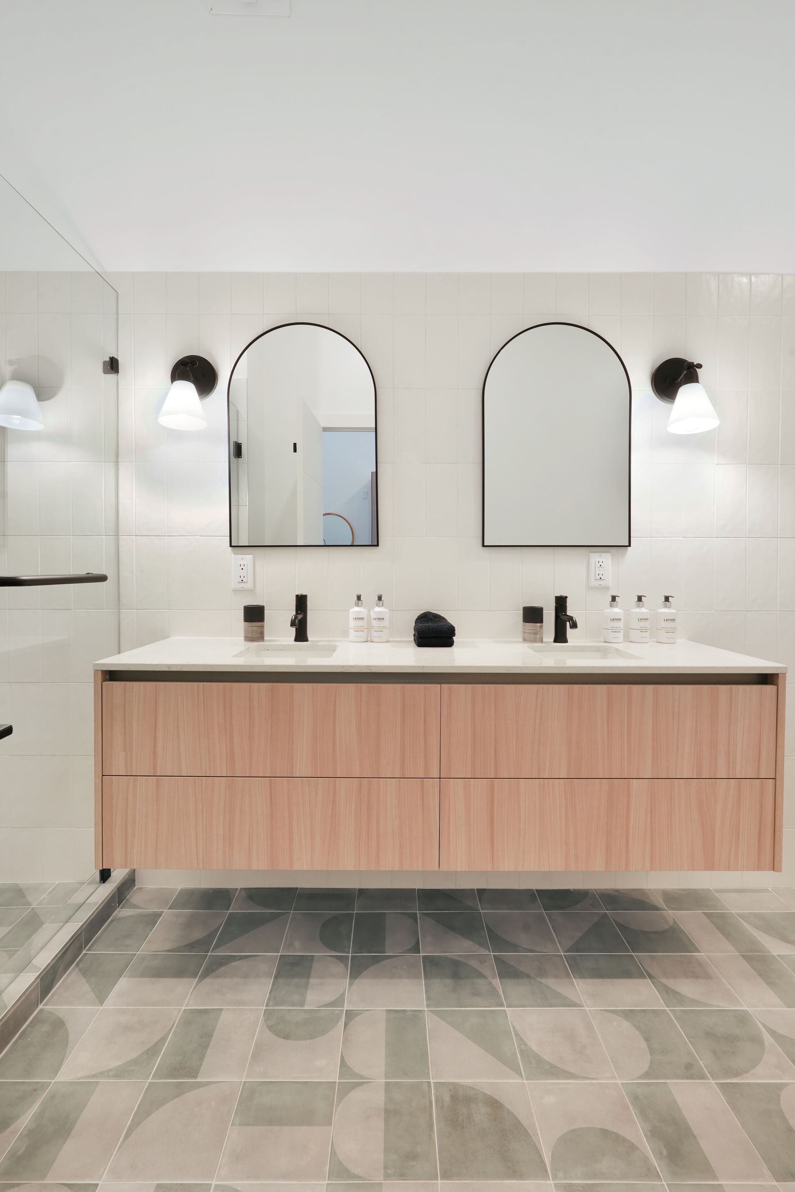 Un baño moderno con dos lavabos, un espejo grande y un mueble de tocador de madera.