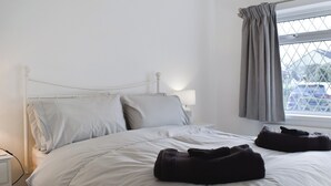 A neatly made bed with pillows and a blanket, a bedside lamp, and a window with curtains. - 2 bedroom accommodation in Sockbridge, near Ullswater (Sockbridge, near Ullswater)