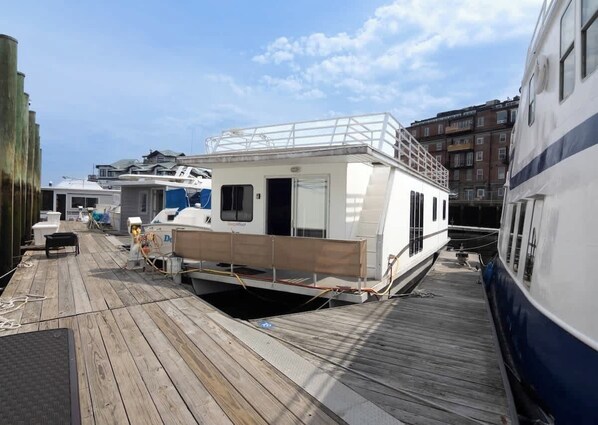 A docked boat with a covered deck area, a cabin, and a small open space.