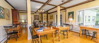 Comfortable room with queen bed and twin trundle, a stunning view of Mount Mansfield, sitting area with couch and a parlor stove with full service breakfast included