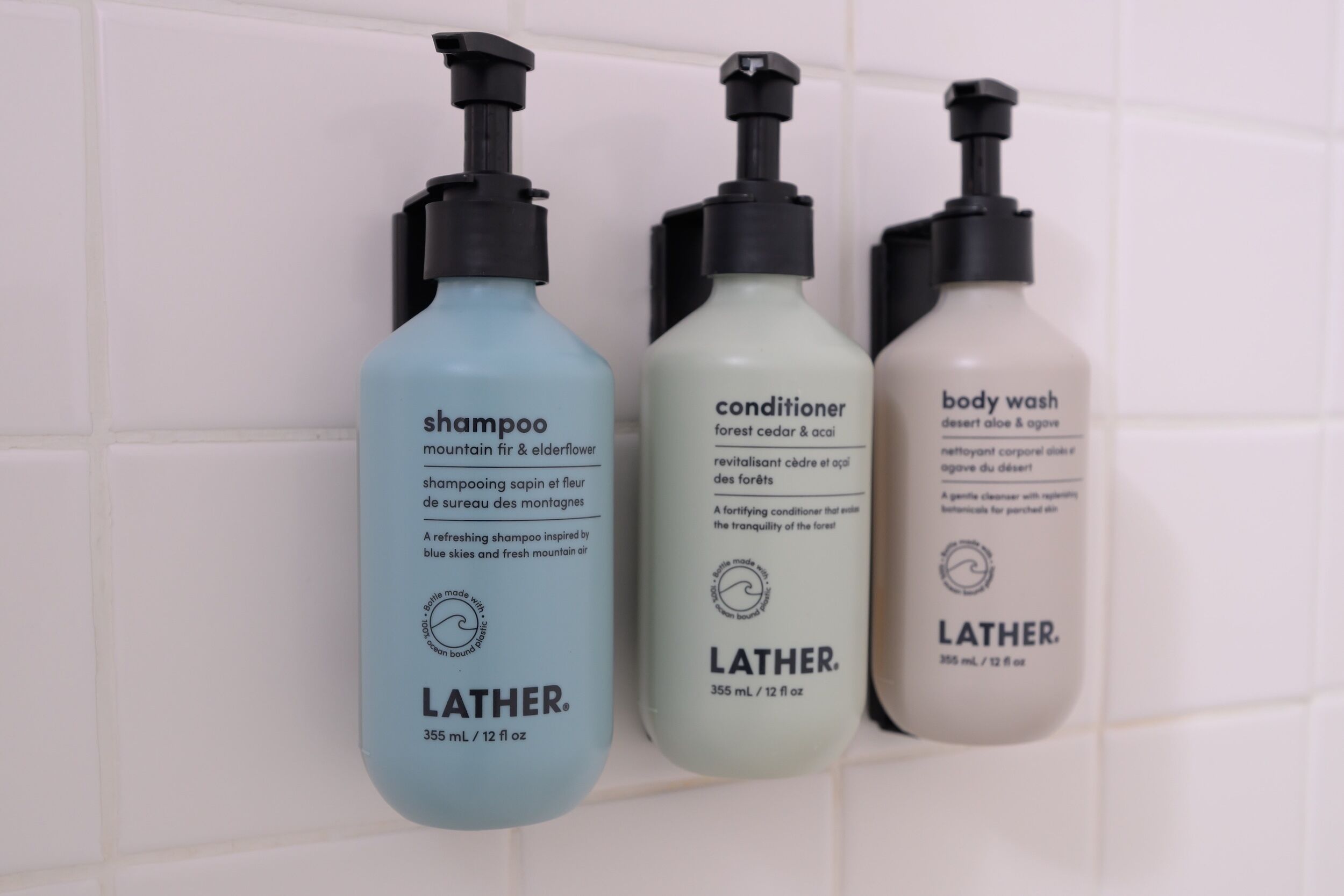Three Lather brand bottles of shampoo, conditioner, and body wash.