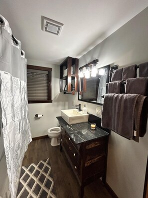 Ein Badezimmer mit Toilette, Waschbecken und Spiegel.