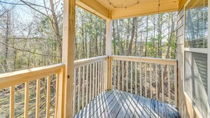 Ein überdachter Balkon mit Blick auf einen Wald.