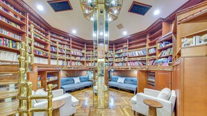 Eine Bibliothek mit Bücherregalen, Sofas und einer zentralen Säule.